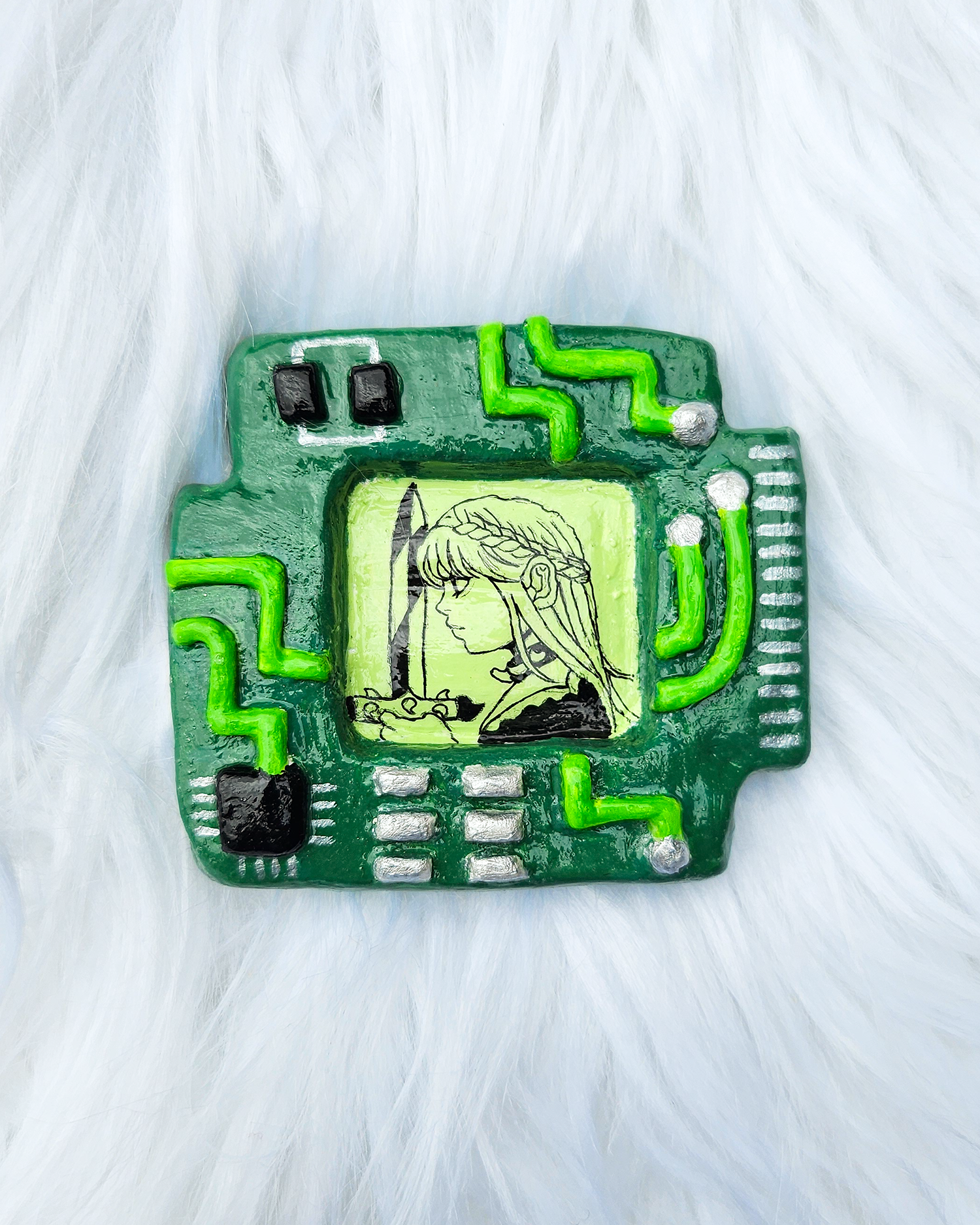 Green square circuitboard shaped clay sculpture with a screen-like shape in the centre with a pen drawing of a girl holding a sword. 