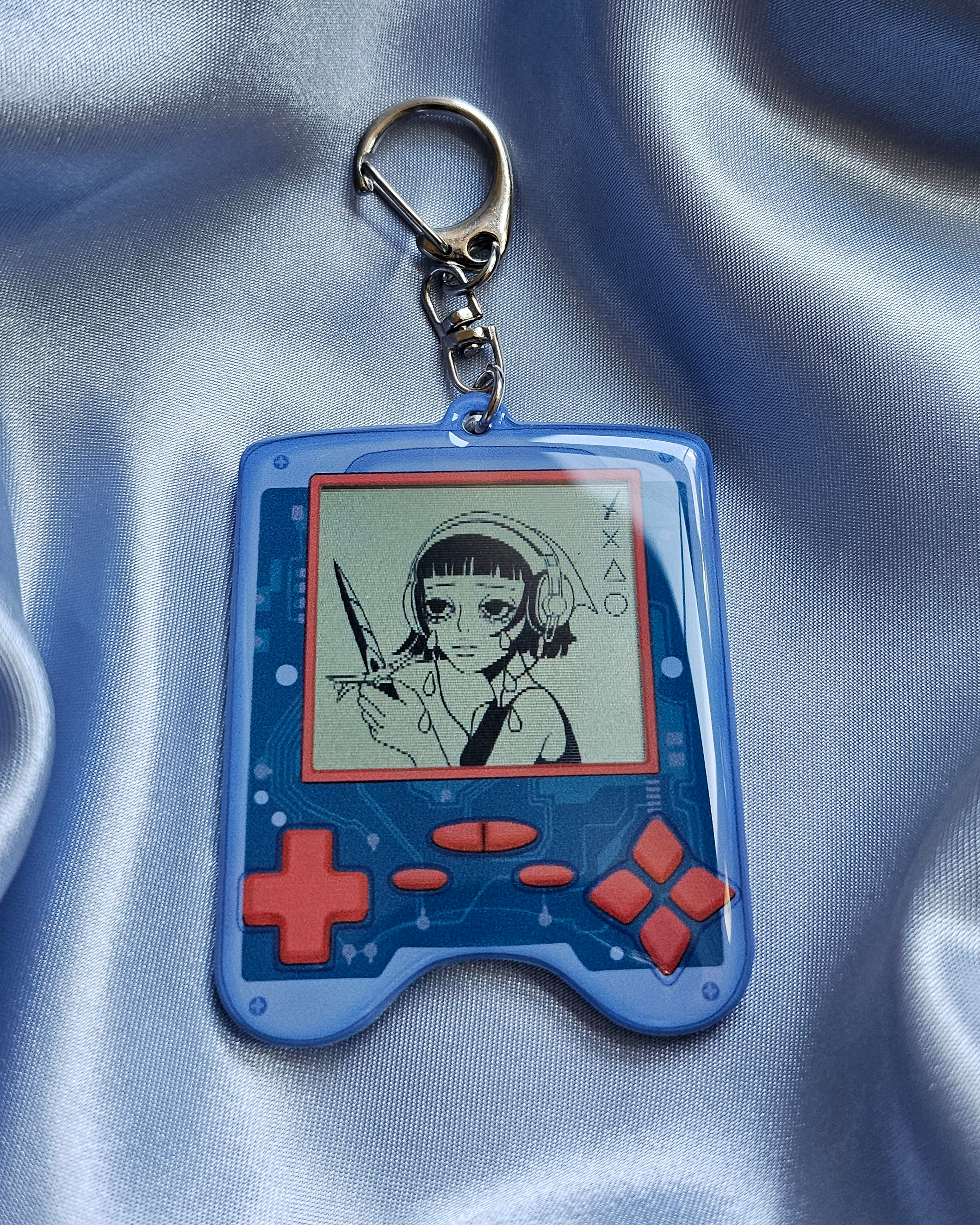 Keychain of a game device with a lenticular effect girl crying on the screen.
