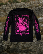 Black long-sleeve shirt with pink graphic design of an angel holding a sword screen-printed on it. She has a CD halo on her head and there rectangular is a border made of wires surrounding her. The sleeves have sword designs on each arm. 
