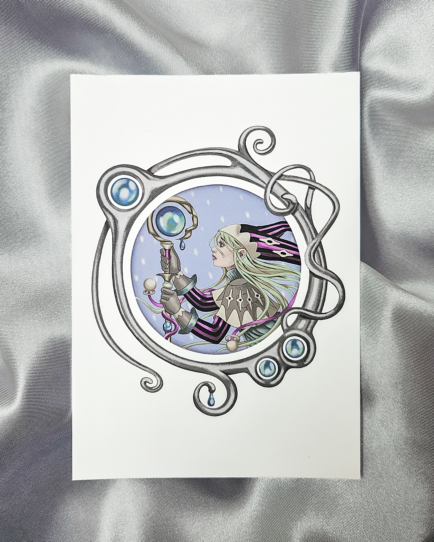 Postcard print of illustration of a fantasy character with a staff surrounded by a decorative metallic looking border.