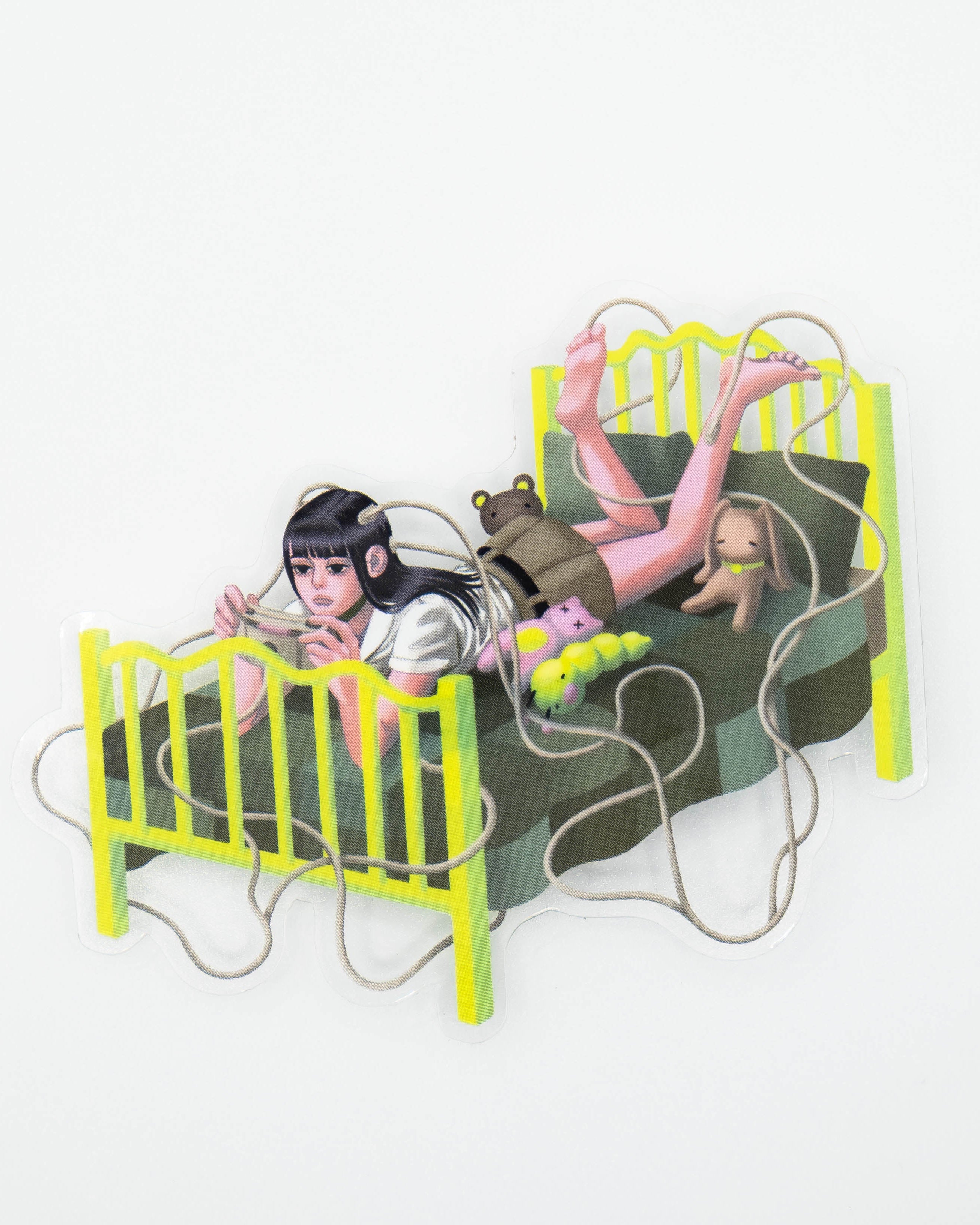 Transparent sticker of pink coloured girl lying on bed playing a game device. There are wires coming out of her head. 